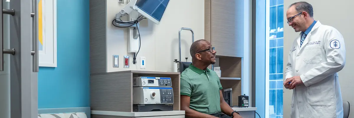 Head and neck surgeon Dr. Thomas J. Ow talks with his patient in an MSK exam room. 