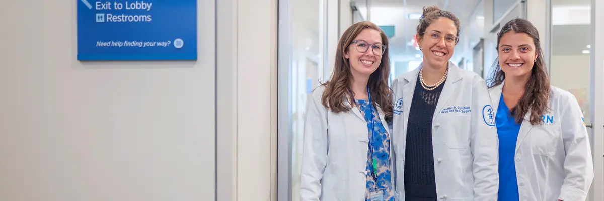 Head and neck surgeon Dr. Jennifer Cracchiolo with two female colleagues stand in a hallway at MSK.  