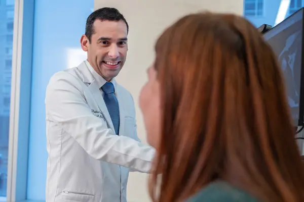 Rehabilitation medicine doctor Jesuel Padro-Guzman examining his patient at MSK in New York City.   