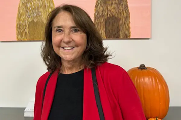 Family photo of Karren Tyler standing in front of a large pumpkin and artwork.