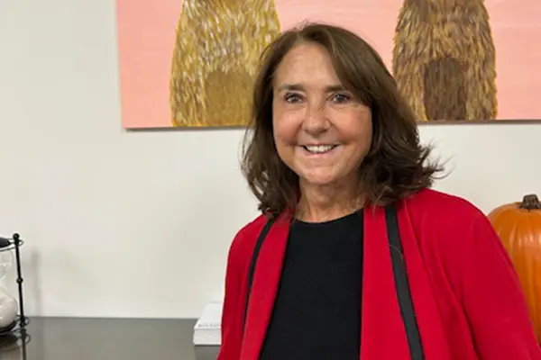 Family photo of Karren Tyler standing in front of a large pumpkin and artwork.