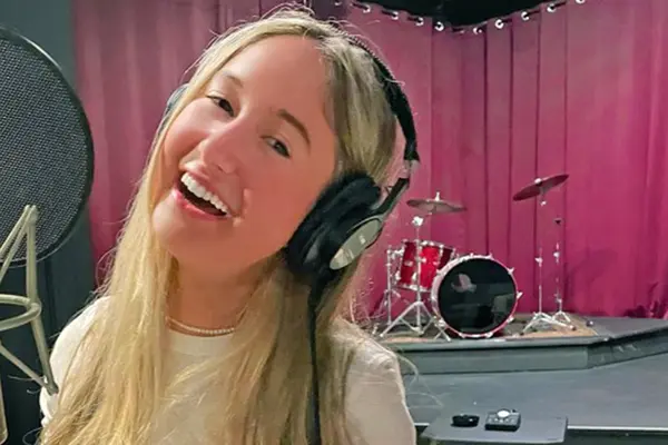 Thyroid cancer survivor Annabel Gutherz, treated for cancer at MSK, is singing in front of a microphone in a recording studio.
