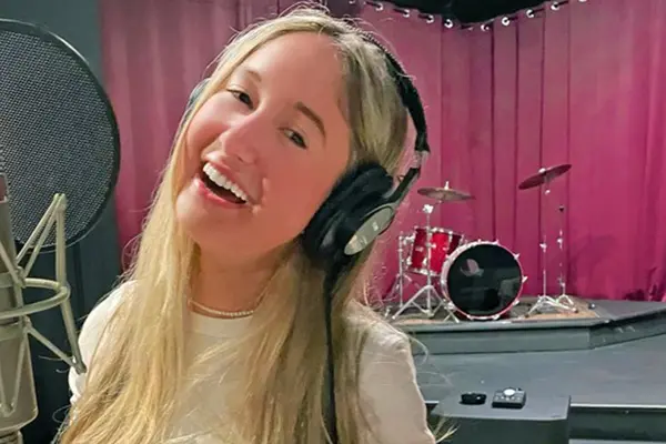 Thyroid cancer survivor Annabel Gutherz, treated for cancer at MSK, is singing in front of a microphone in a recording studio.   