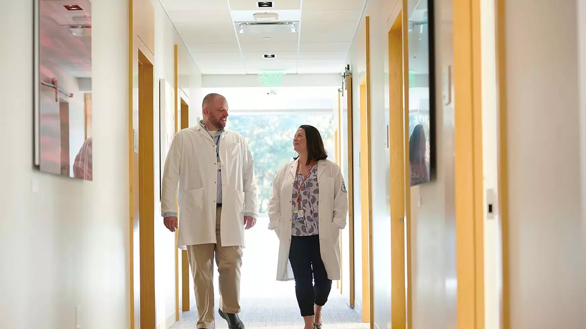 Nurse Bryon Wanderer and nurse practitioner Erin Scansarole walking in the hall