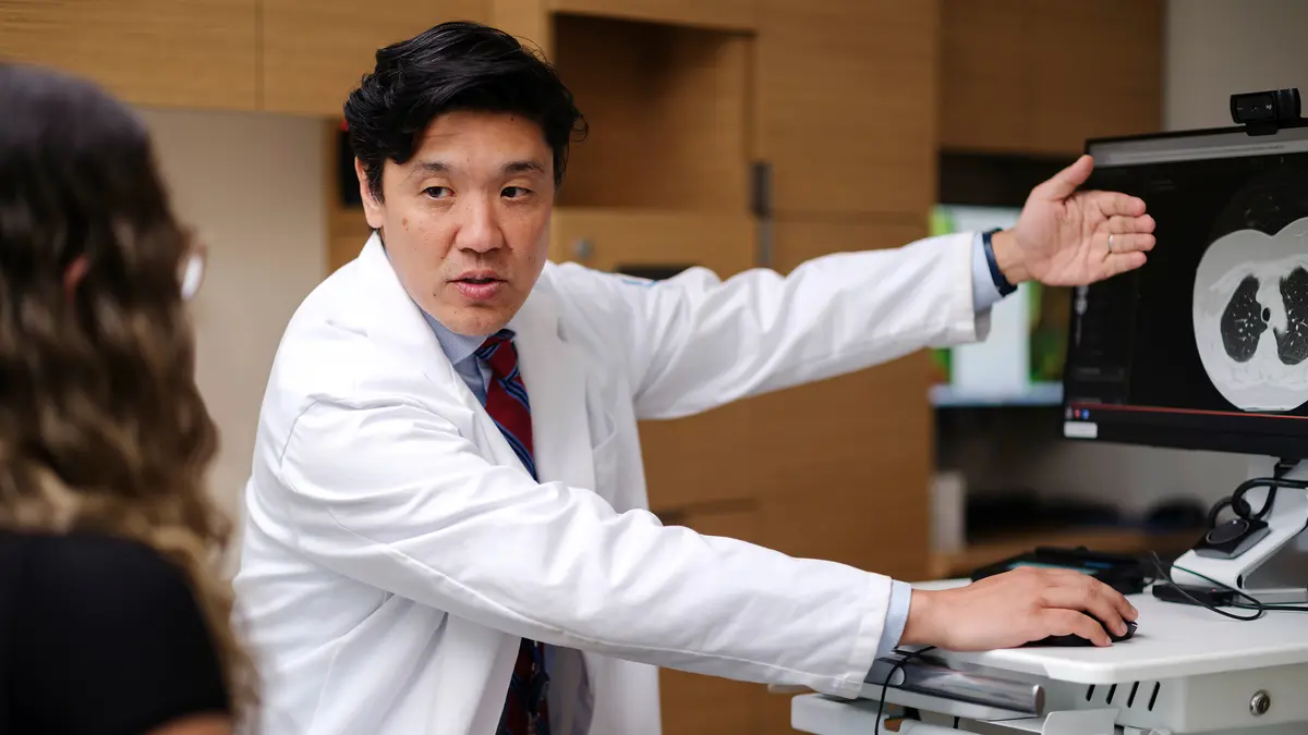 Head and neck medical oncologist Dr. Alan L. Ho, Chief of MSK’s Head and Neck Oncology Service, points to a scan image on a computer monitor as he talks with his patient. 