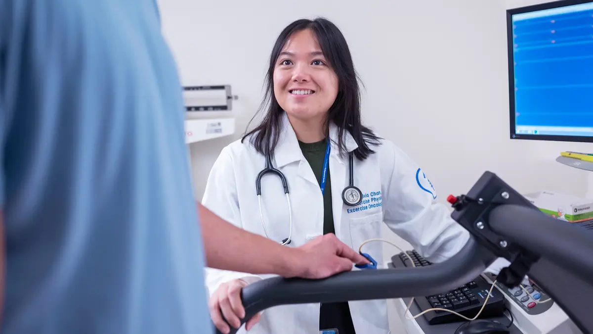 An exercise physiologist works with an MSK patient who is using exercise equipment.   