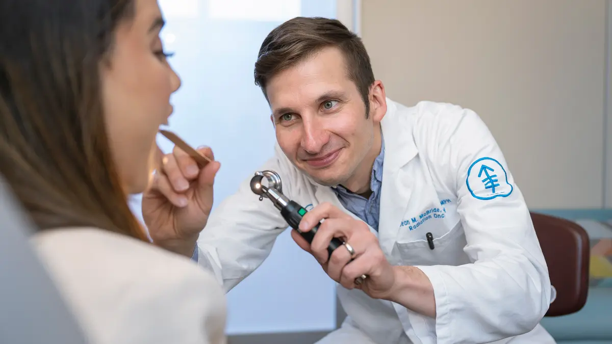 Radiation oncologist Dr. Sean McBride examines the mouth of his MSK patient in New York City. 